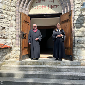 Prädikant Angne und Pfarrerin Poirot vor dem Portal der Christuskirche.